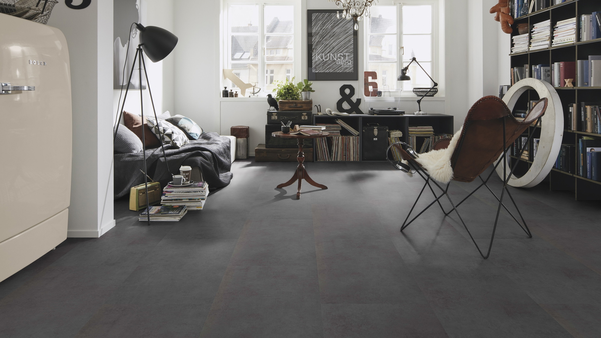 Milieubild Kompaktes Wohnzimmer mit Bücherregal - wineo Klebe-Bioboden PURLINE wineo 1500 stone XL Portland Concrete Dark Milieubild Kompaktes Wohnzimmer mit Bücherregal - wineo PL15406SXL