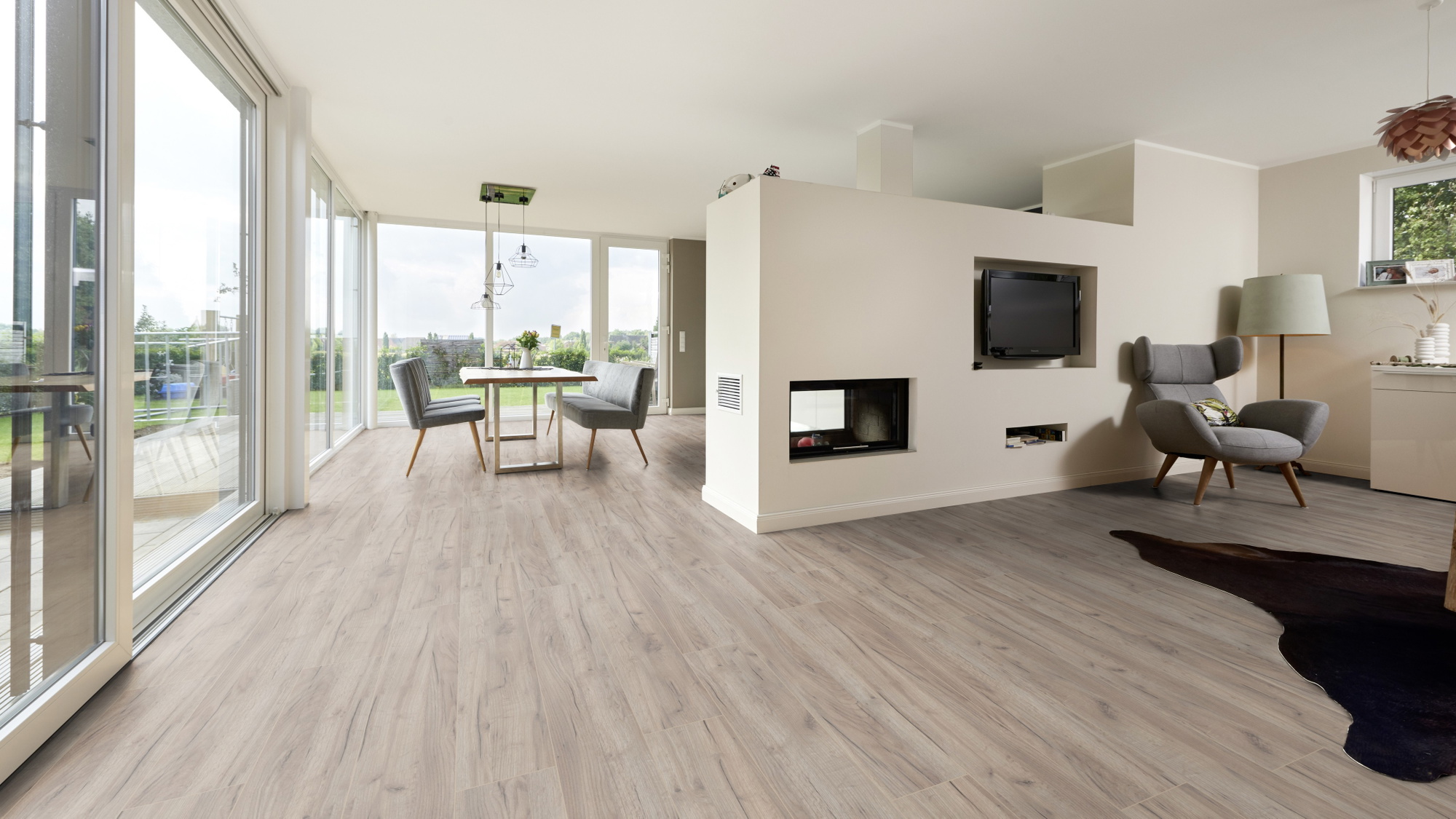 Milieubild Wohnzimmer mit Essbereich und Kamin - ter Hürne Klick-Designboden Dureco Strong Classic Edition Eiche Tahiti Milieubild Wohnzimmer mit Essbereich und Kamin - ter Hürne 1101260048