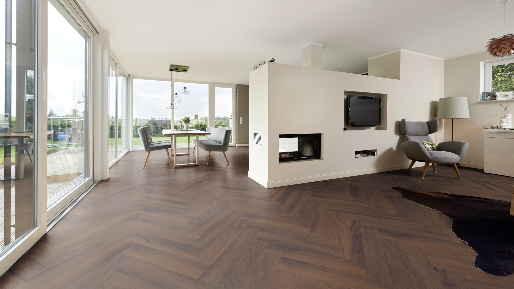 Milieubild Wohnzimmer mit Essbereich und Kamin - ter Hürne Laminat Herringbone Edition Eiche Estate Milieubild Wohnzimmer mit Essbereich und Kamin - ter Hürne 1101021852