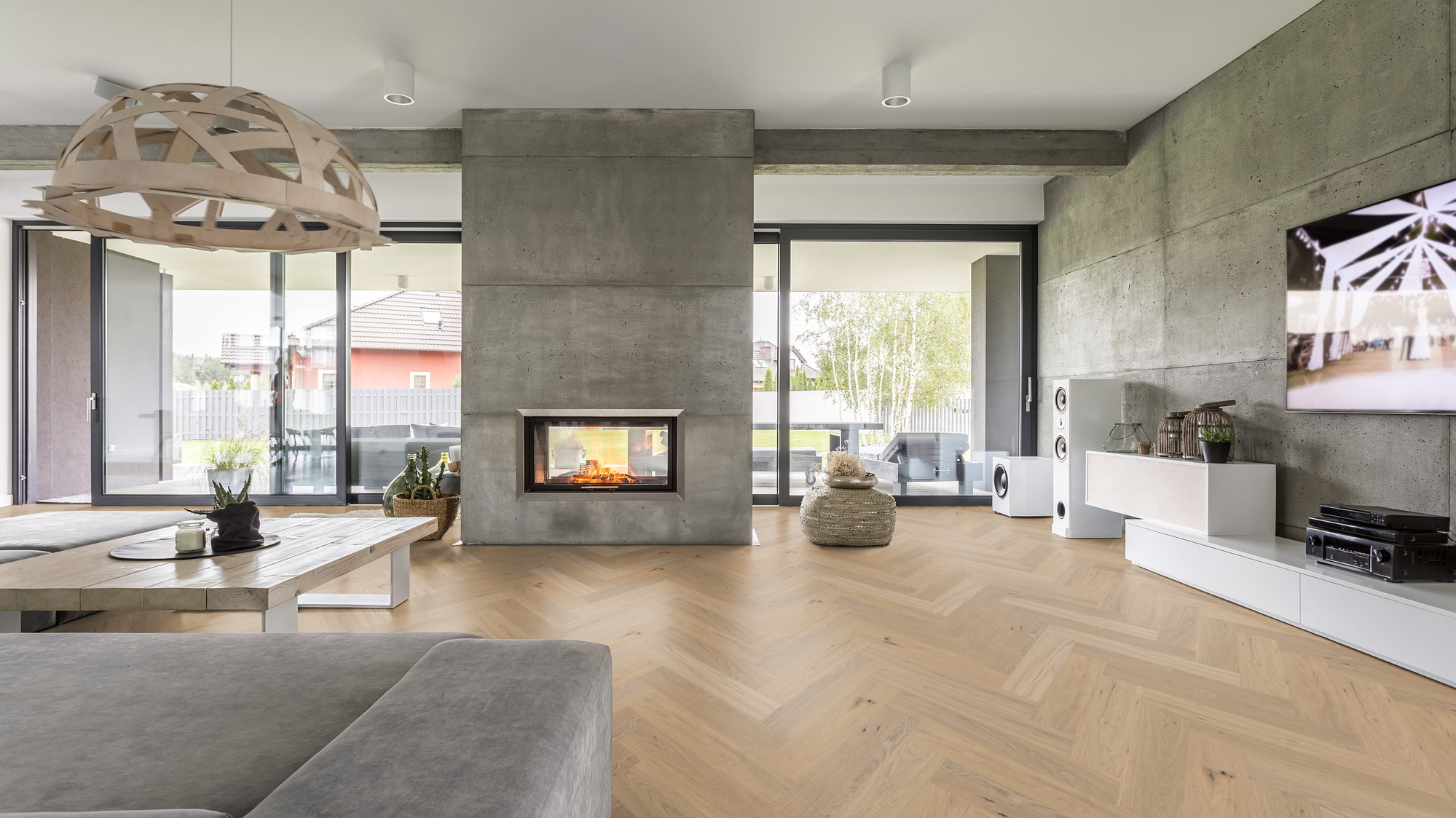 Milieubild Wohnzimmer mit Kamin und Betonwänden - Thede & Witte Parkett Maxistab Eiche Rohoptik Milieubild Wohnzimmer mit Kamin und Betonwänden - Thede & Witte 52MSÖNF15EI53