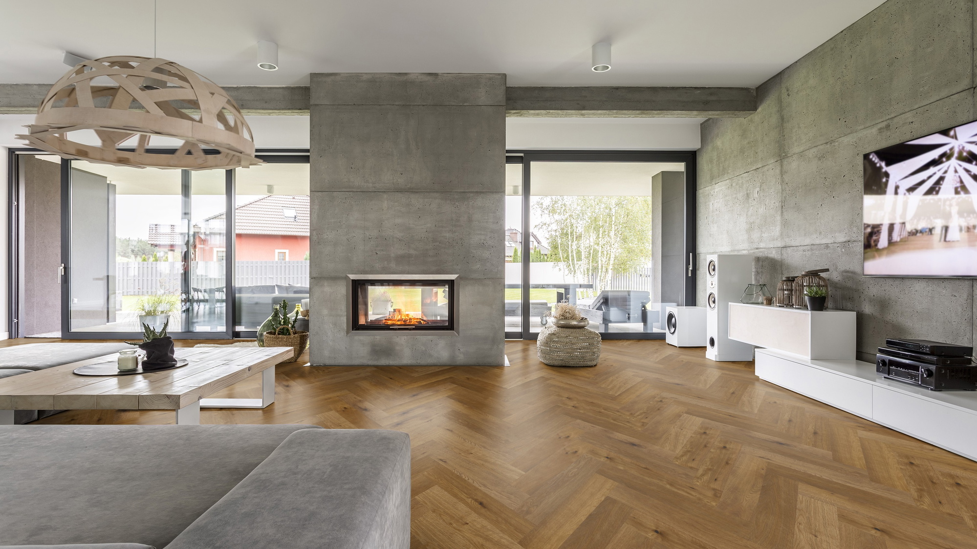 Milieubild Wohnzimmer mit Kamin und Betonwänden - Thede & Witte Parkett Maxistab Eiche geräuchert Milieubild Wohnzimmer mit Kamin und Betonwänden - Thede & Witte 52MSÖENF15EI65