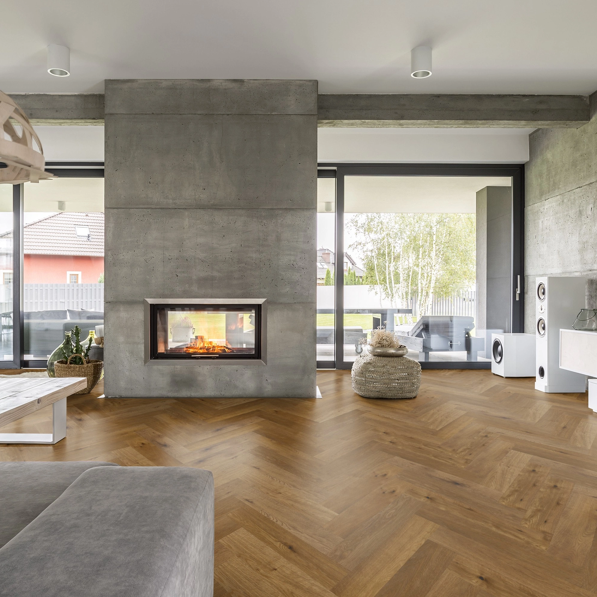 Milieubild Wohnzimmer mit Kamin und Betonwänden - Thede & Witte Parkett Maxistab Eiche geräuchert Milieubild Wohnzimmer mit Kamin und Betonwänden - Thede & Witte 52MSÖENF15EI65