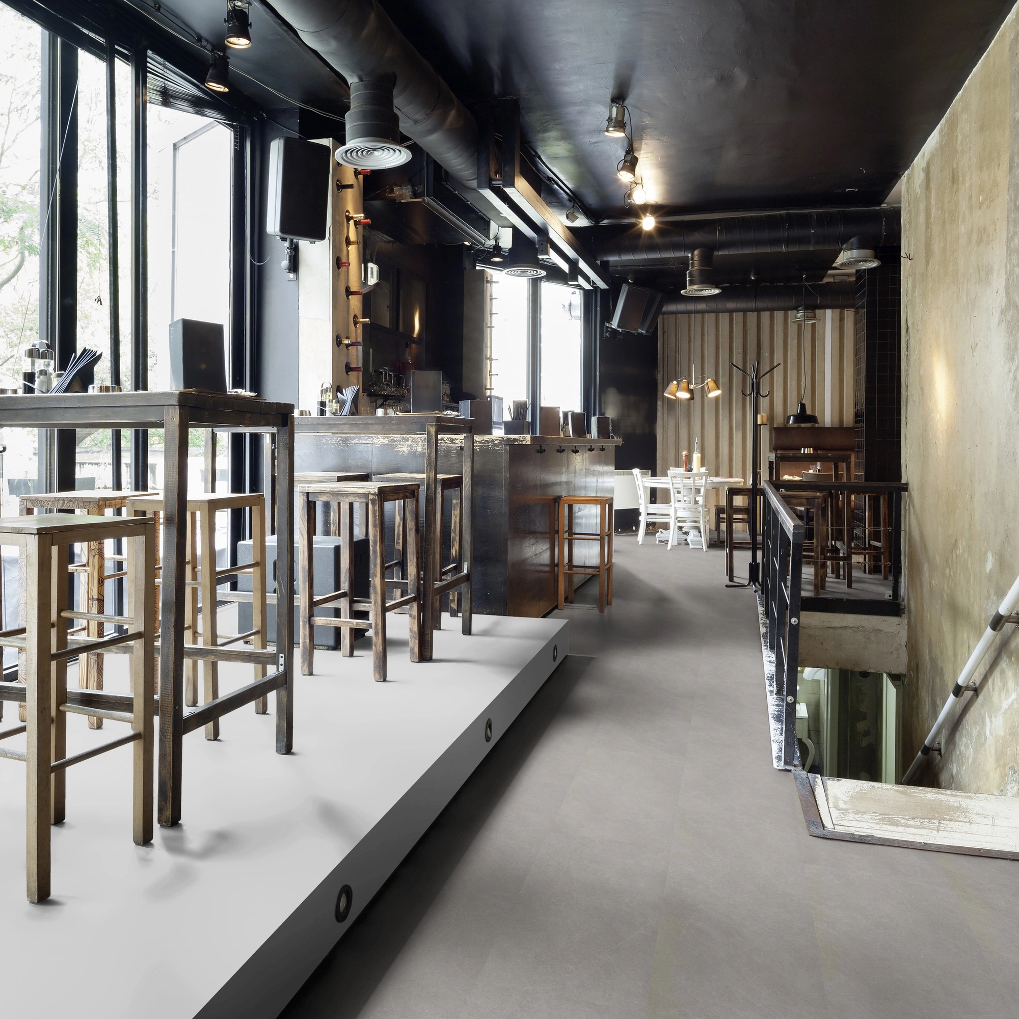 Milieubild Restaurant - Bar mit Tischen und Hockern - wineo Klebe-Bioboden PURLINE wineo 1500 stone XL Modern Stone Grey Milieubild Restaurant - Bar mit Tischen und Hockern - wineo PL15404SXL