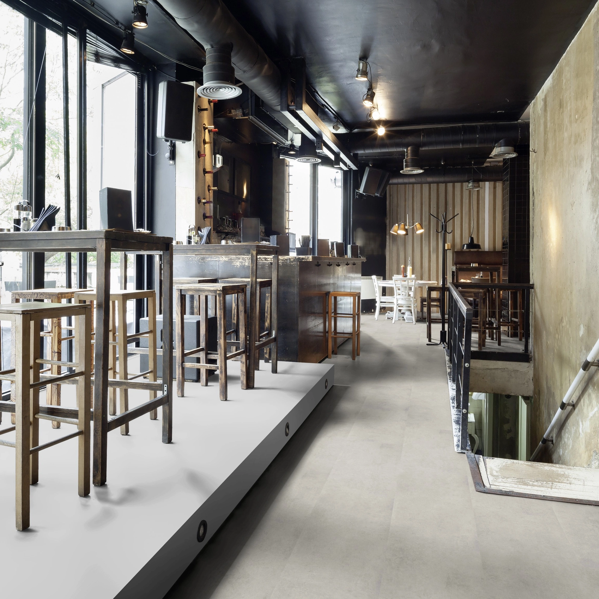 Milieubild Restaurant - Bar mit Tischen und Hockern - wineo Klebe-Bioboden PURLINE wineo 1500 stone XL Portland Concrete Light Milieubild Restaurant - Bar mit Tischen und Hockern - wineo PL15408SXL