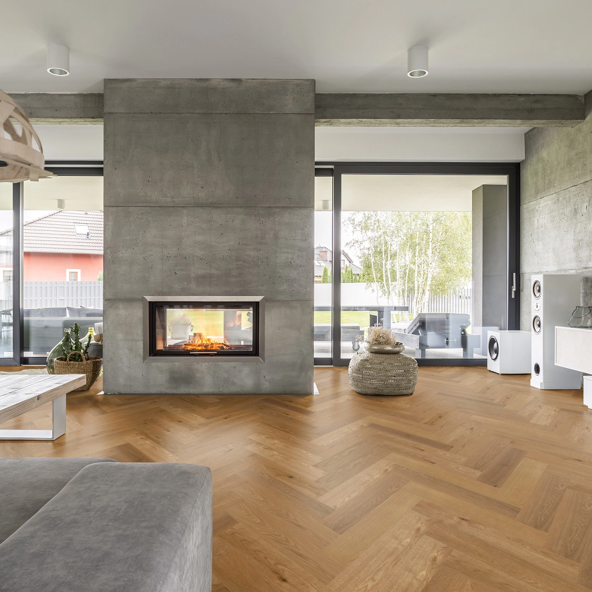 Milieubild Wohnzimmer mit Kamin und Betonwänden - Thede & Witte Parkett Maxistab Eiche Milieubild Wohnzimmer mit Kamin und Betonwänden - Thede & Witte 52MSÖNF15EI50