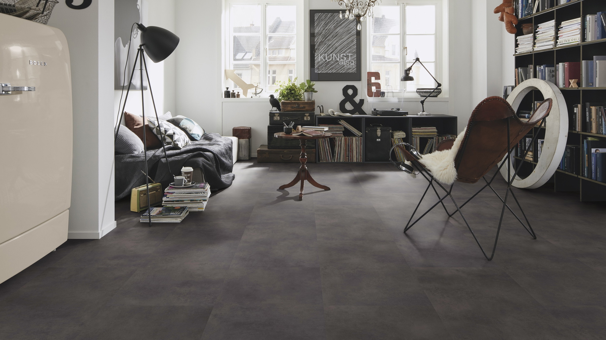 Milieubild Kompaktes Wohnzimmer mit Bücherregal - wineo Klebe-Bioboden PURLINE wineo 1500 stone XL Loft Concrete Dark Milieubild Kompaktes Wohnzimmer mit Bücherregal - wineo PL15400SXL